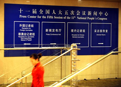 2月26日，一名工作人員從全國兩會新聞中心的標(biāo)識牌旁走過。新華社記者 燕雁 攝