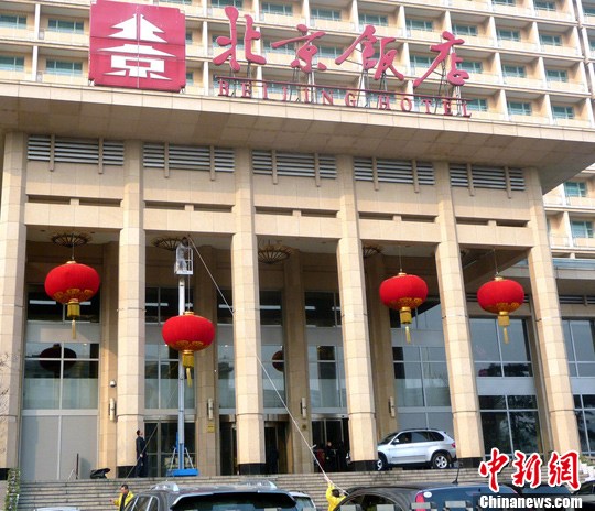 2012年2月27日，北京飯店主樓門前，工作人員正在懸掛大紅燈籠、營造喜慶氣氛，迎接全國“兩會”的召開。