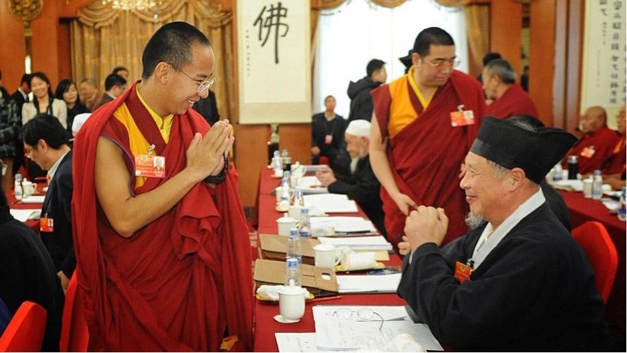 3月5日下午，參加全國政協(xié)十一屆五次會議的宗教界委員舉行小組會議，討論溫家寶總理所作政府工作報告。圖為十一世班禪向中國道教協(xié)會副會長劉懷元致意。