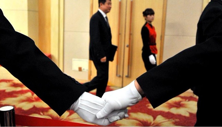 2012年3月10日，2012全國兩會，政協(xié)委員談發(fā)展新能源和清潔能源。安保人員手牽手護送委員退場。