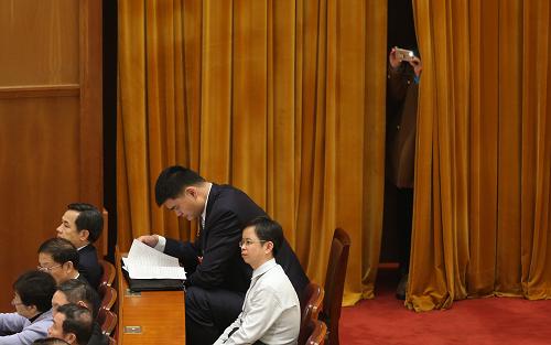  3月3日，中國人民政治協(xié)商會議第十二屆全國委員會第一次會議在北京人民大會堂開幕。這是一名記者在拍照，她面前是在靜靜聽會的“小巨人”姚明委員。新華社記者 金立旺 攝